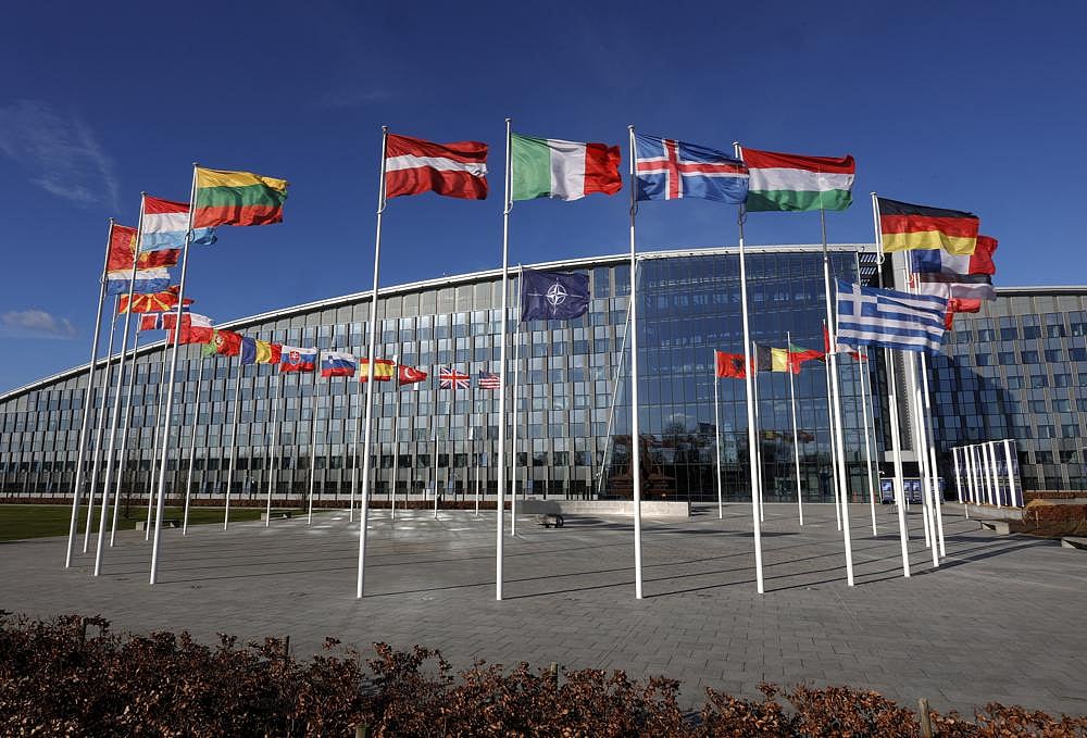 Flags flutter in the wind outside NATO headquarters in Brussels, on Feb. 7, 2022 | AP