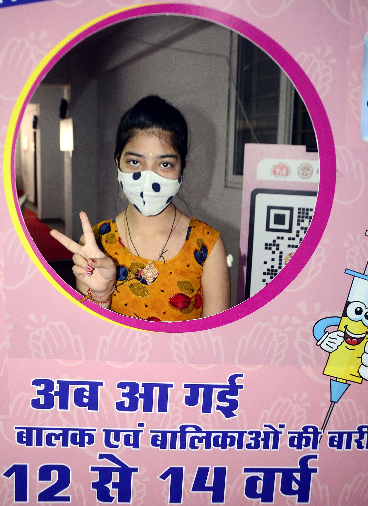 A girl flashes victory sign after receiving vaccine in Bhopal on Wednesday