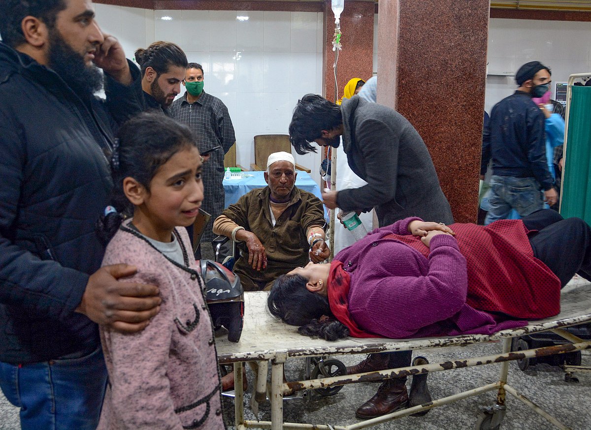 Relatives attend a wounded woman as she gets treated at a hospital after a grenade explosion in Srinagar city, on Sunday
