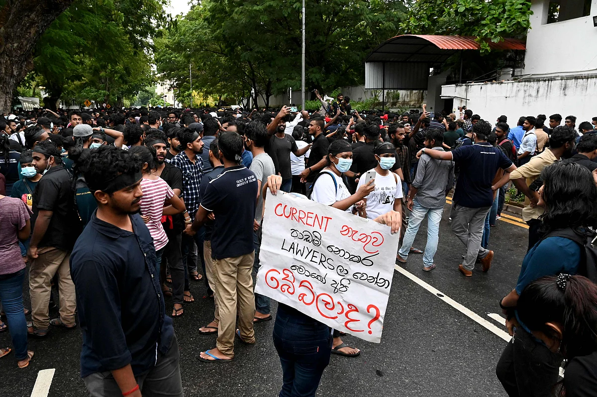 Demonstrators take part in a protest against the surge of prices and shortage of fuel and other essential commodities at the entrance of the Sri Lanka prime minister Mahinda Rajapaksa residence in Colombo on April 5, 2022. | (Photo by ISHARA S. KODIKARA / AFP)