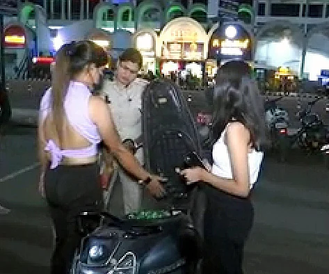 Cop checking two-wheeler of the girls at Rani Kamlapati Railway station in Bhopal on Saturday night.  | FP