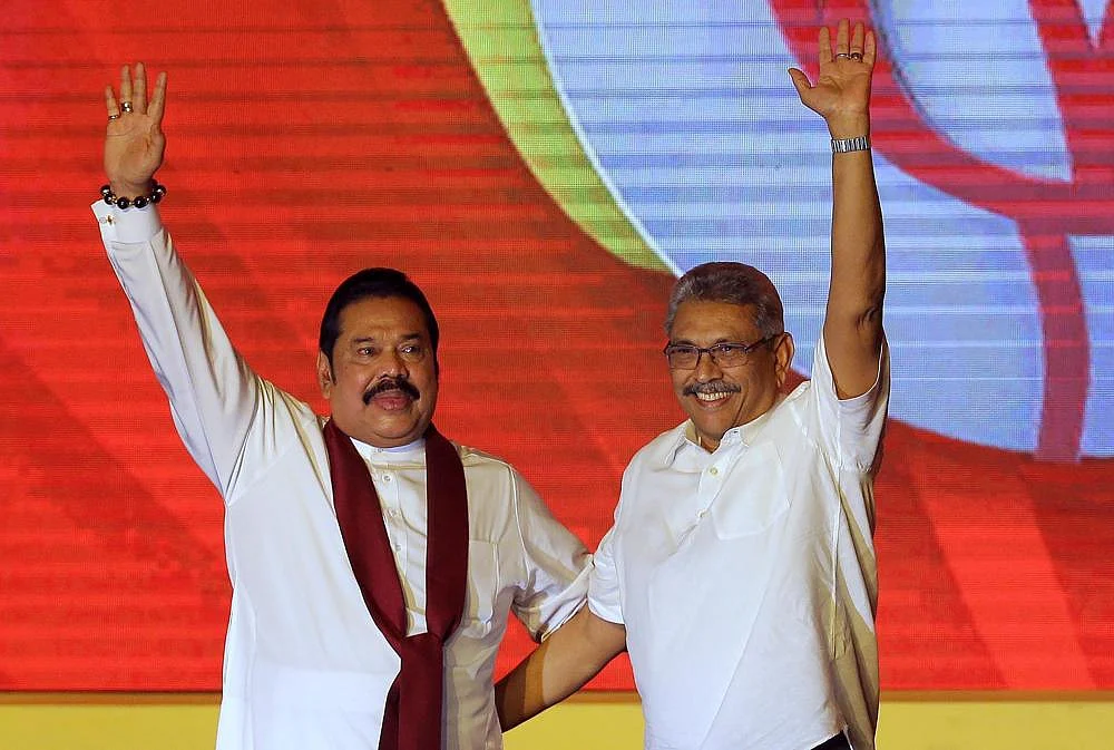 Mahinda Rajapaksa, left, and his brother Gotabaya Rajapaksa wave to supporters during a party convention held to announce the presidential candidacy in Colombo, Sri Lanka, Aug. 11, 2019 | AP