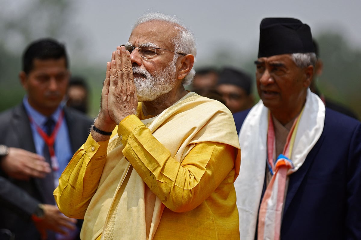 Indias Prime Minister Narendra Modi gestures as his Nepali counterpart Sher Bahadur Deuba (R) watches after offering prayers at the Mayadevi temple on the occasion of Buddha Purnima, which marks Gautama Buddhas birth anniversary, in Lumbini on May 16, 2022. |  (Photo by SUBASH SHRESTHA / AFP)