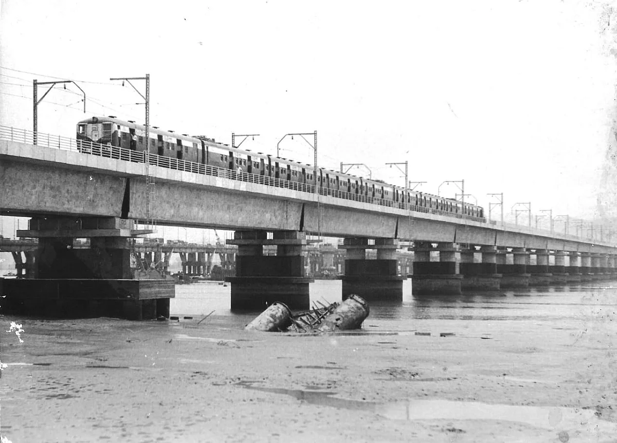 Picture of a 9 coach local train on Vashi creek bridge, comming towards CSMT in some where in 1992. | 