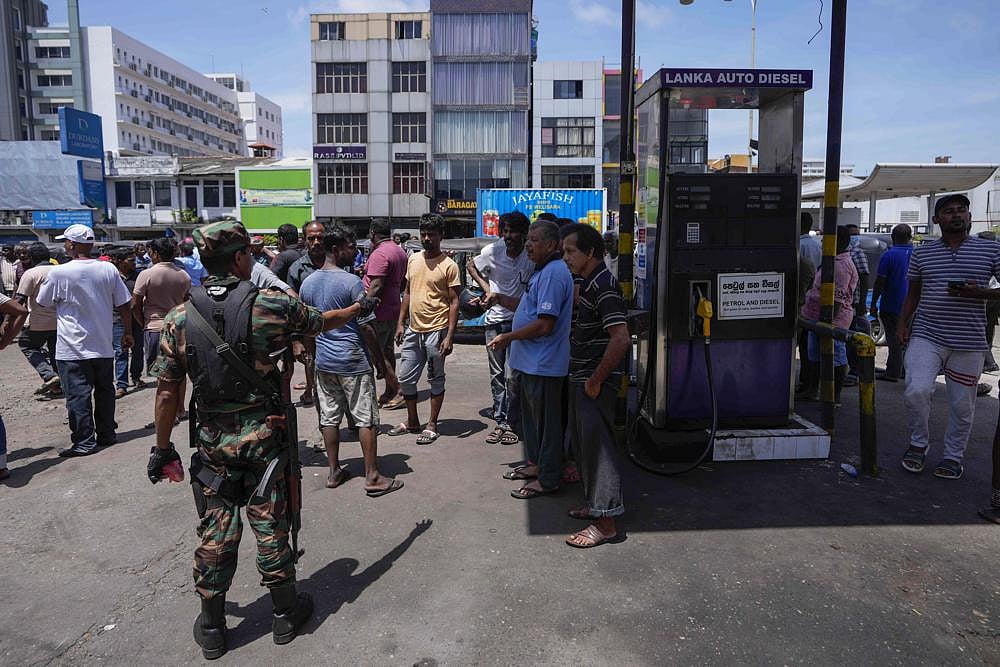 An army soldier tries to calm down people demanding fuel at a fuel station in Colombo, Sri Lanka, on Monday, June 27 | AP