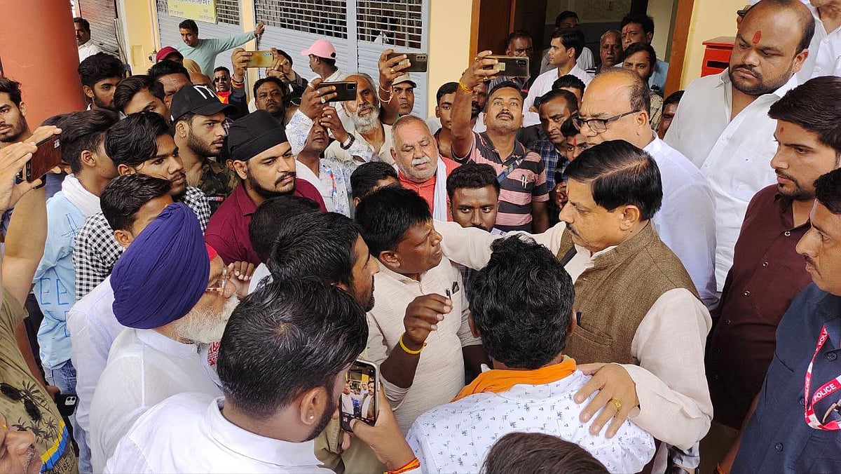 Cabinet minister Mohan Yadav tries to pacify outgoing corporator from ward-53 Sunil Borasi who staged a demonstration at the BJP headquarters for not giving him a ticket in Ujjain on Sunday. FP PHOTO | 