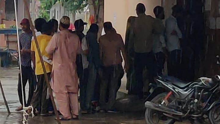 people standing under the shed of a tarpaulin in Ujjain