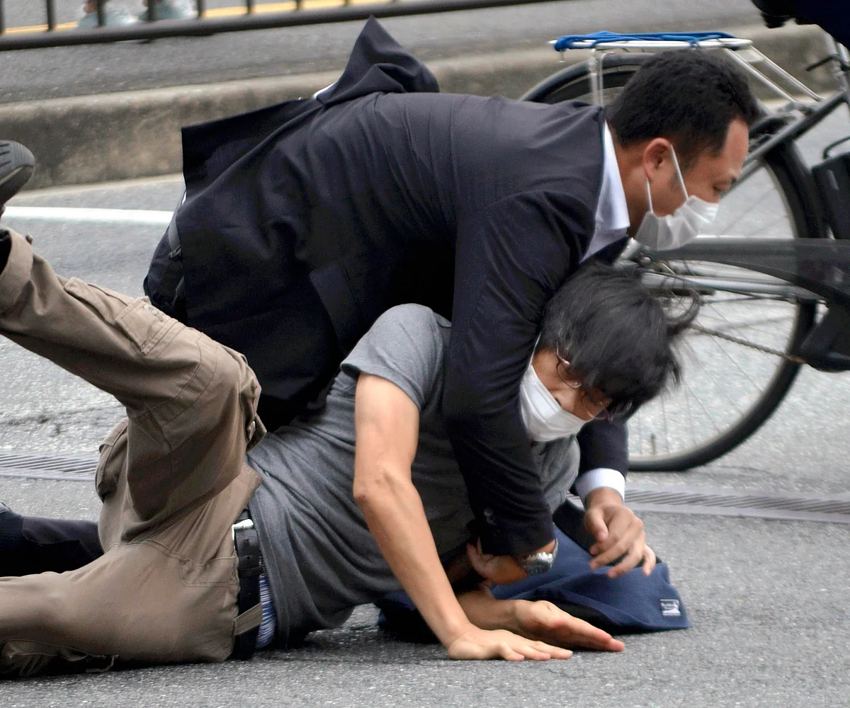 Tetsuya Yamagami, bottom, is detained near the site of gunshots in Nara Prefecture, western Japan, Friday, July 8, 2022. | AP/PTI