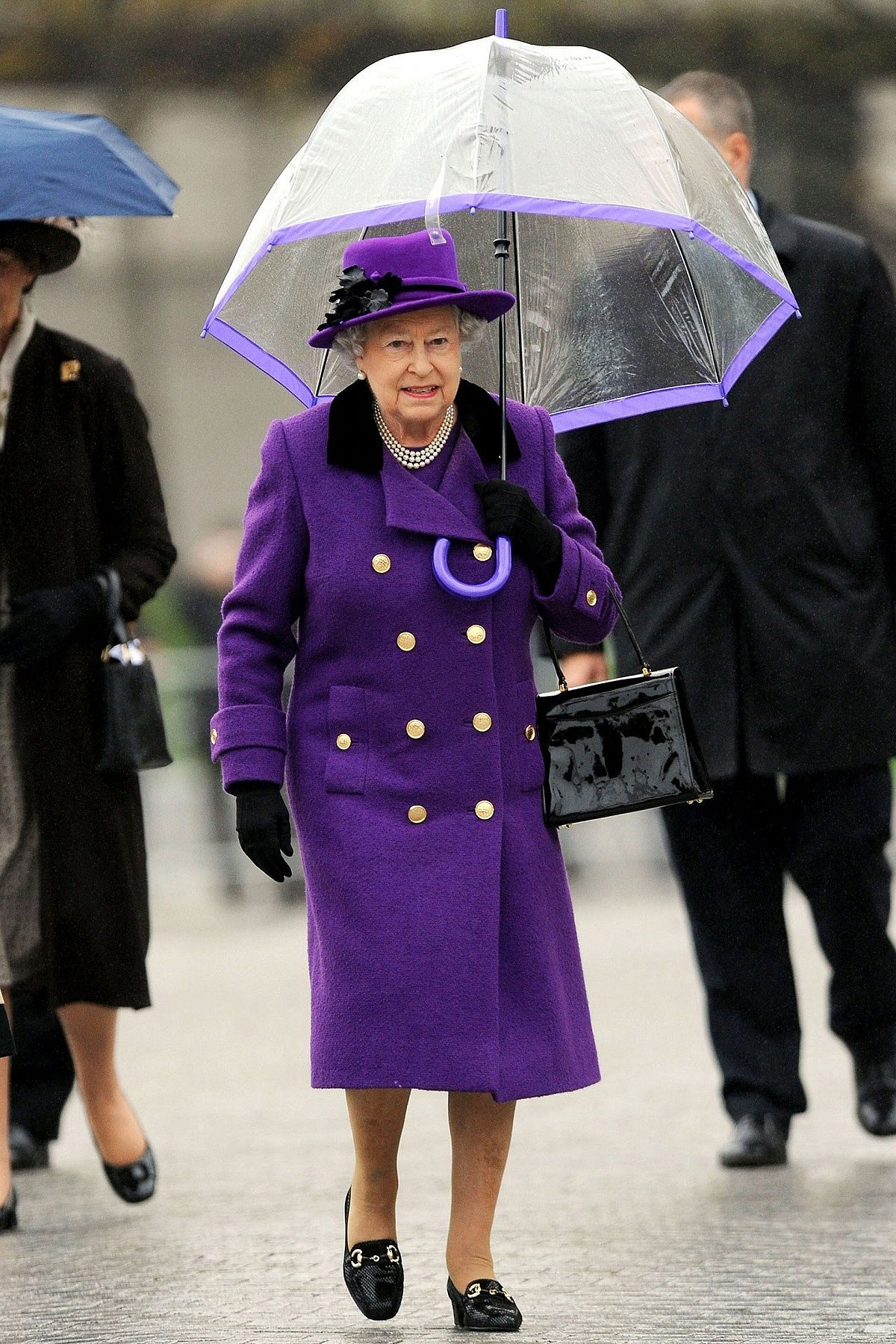 2012: The Queen was monsoon-ready in a vibrant violet double-breasted coat and a dress, and a matching violet-rimmed transparent umbrella as she visited Jubilee Gardens in London’s Southbank.
