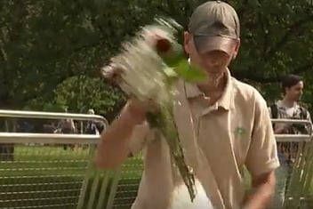A volunteer removing plastic from a flower bouquet left for the late British Monarch Queen Elizabeth II

