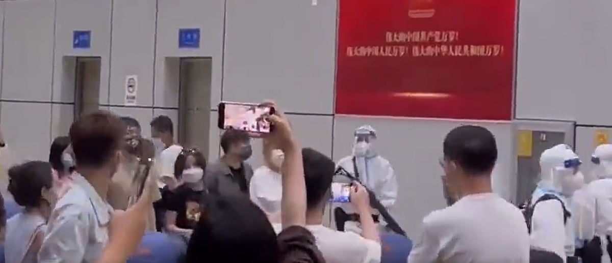 The footage showed people lining up in the airport, while guards armed with assault rifles and fully dressed in Personal Protective Equipment (PPE) gear confronted the crowd | Twitter/@songpingpang