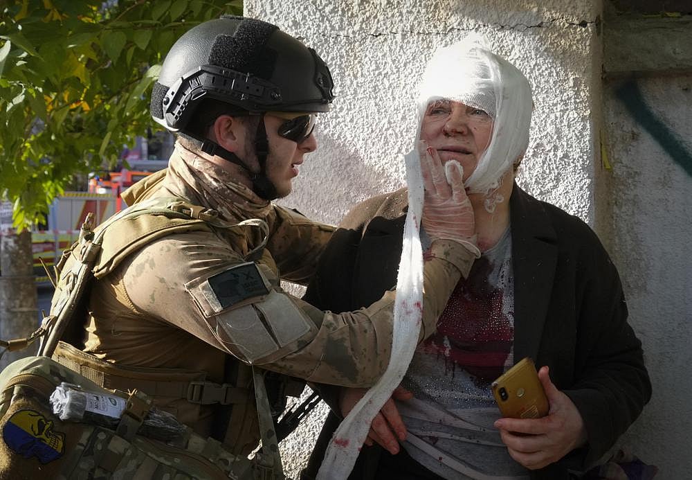 An injured woman receives medical treatment at the scene of Russian shelling, in Kyiv, Ukraine, on October 10