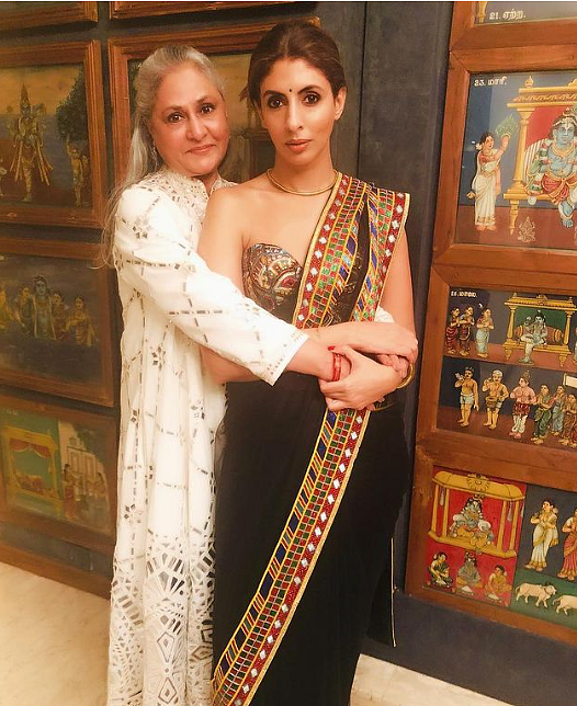 Shweta and Jaya Bachchan posing in front of the wall art.