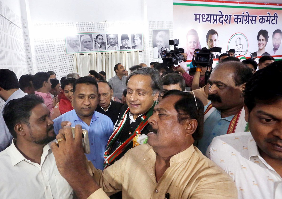 Congress MP Shashi Tharoor poses for a selfie with a party supporter as he arrives for a press conference during his campaign for the upcoming party Presidential elections, at PCC headquarters, in Bhopal on Friday.