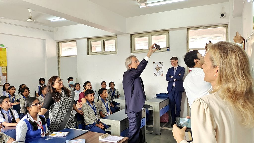 The Ambassador of France to India, HE Emmanuel Lenain, poses for a selfie with government school students and teachers in New Delhi on November 1, 2022.