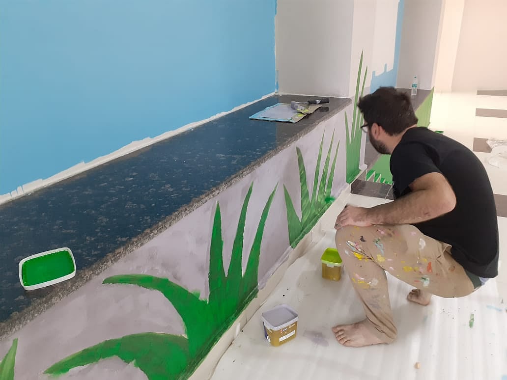 French painter Monsieur Poes making his artwork on a wall across the entry to Gauranjini Auditorium at the Ravindra Convention Centre in the city on Friday.