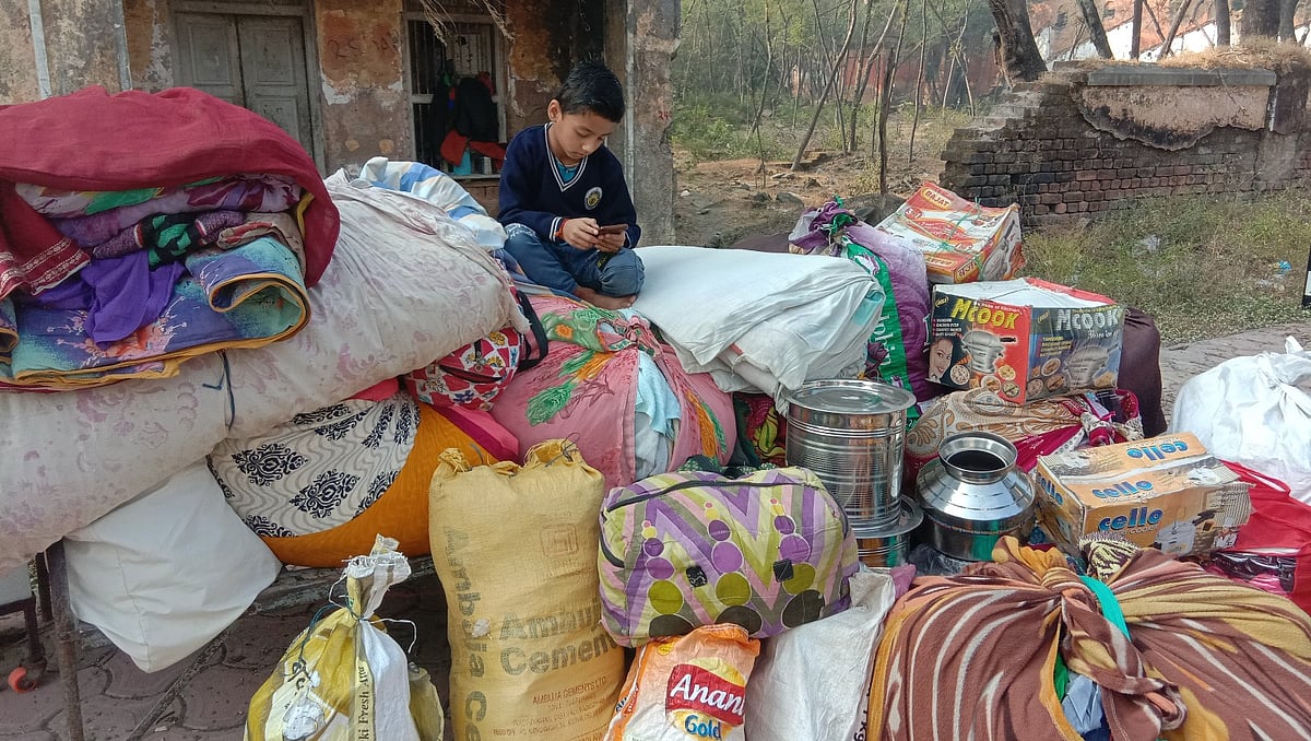 A boy sitting with household items during the pack-up exercise
