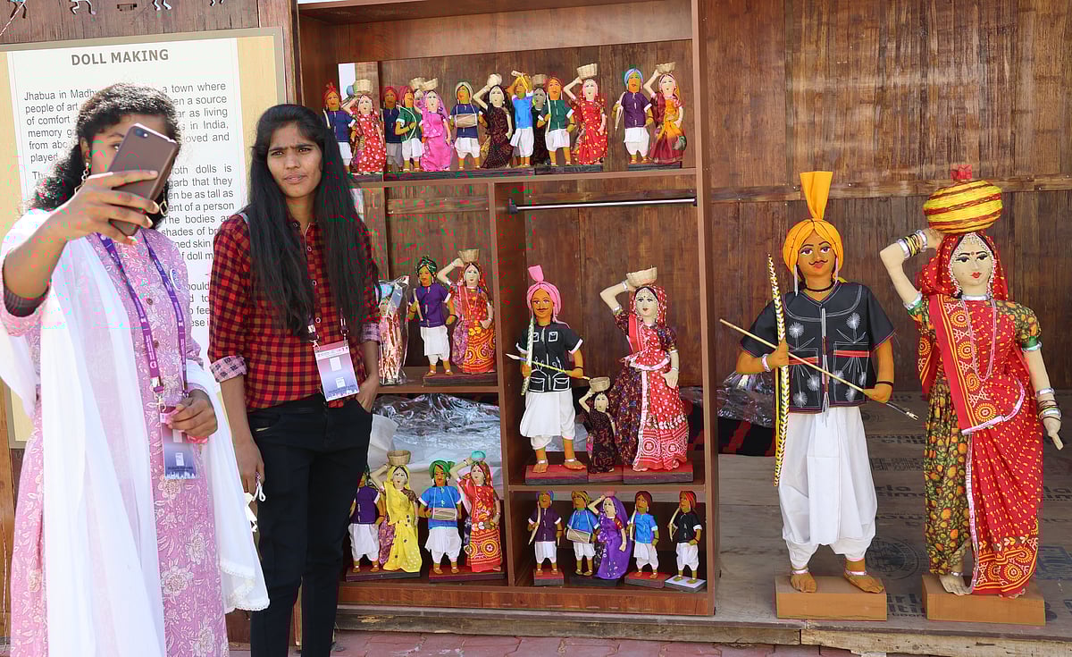 NRIs click a selfie with dolls displayed at the exhibition
