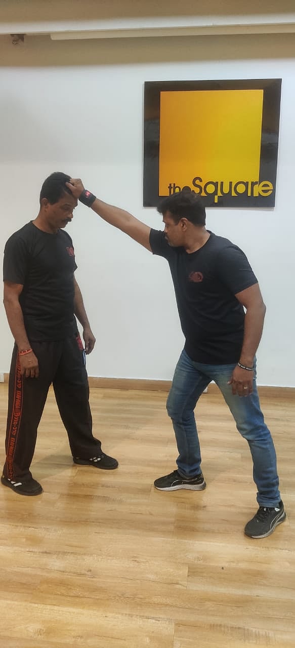 Attacker grabs defender's hair and will pull him down to give a knee kick to his face/ IKMF