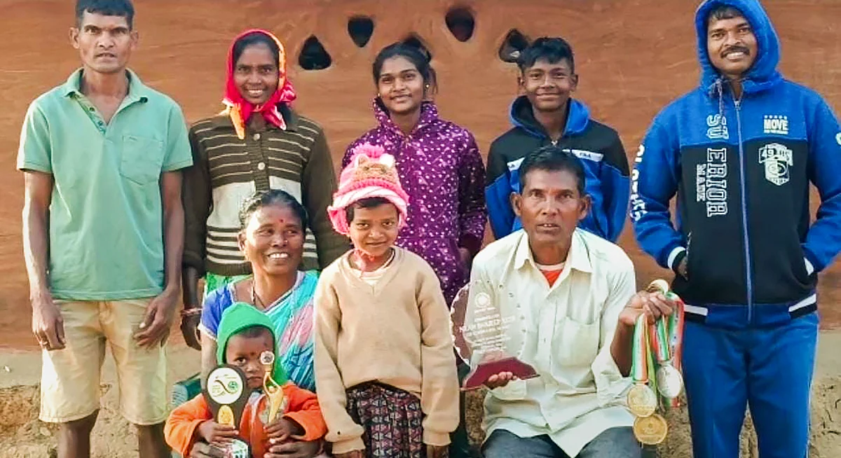 Family members of Indian hockey player Nilam Sanjeep Xess with his trophies at his residence in Kadobahal village of Sundergarh district