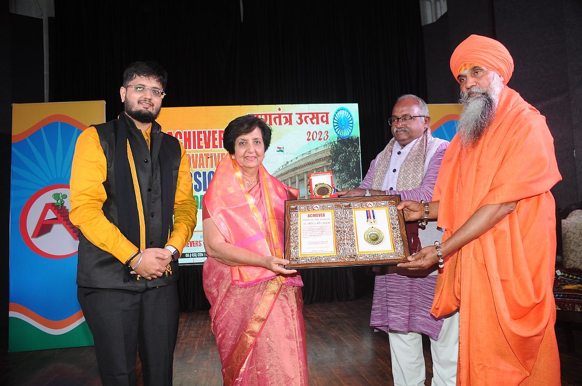Dr Saluja receives award from guests. | 