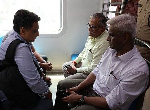 GM is seen interacting with the commuters in a suburban local train.