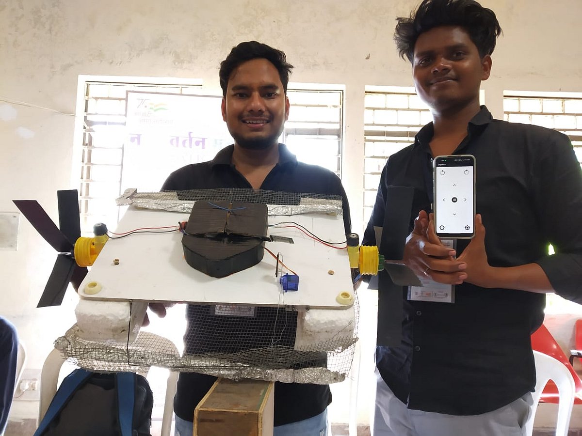 Harish and Devesh Singh showcasing lake cleaner boat.
