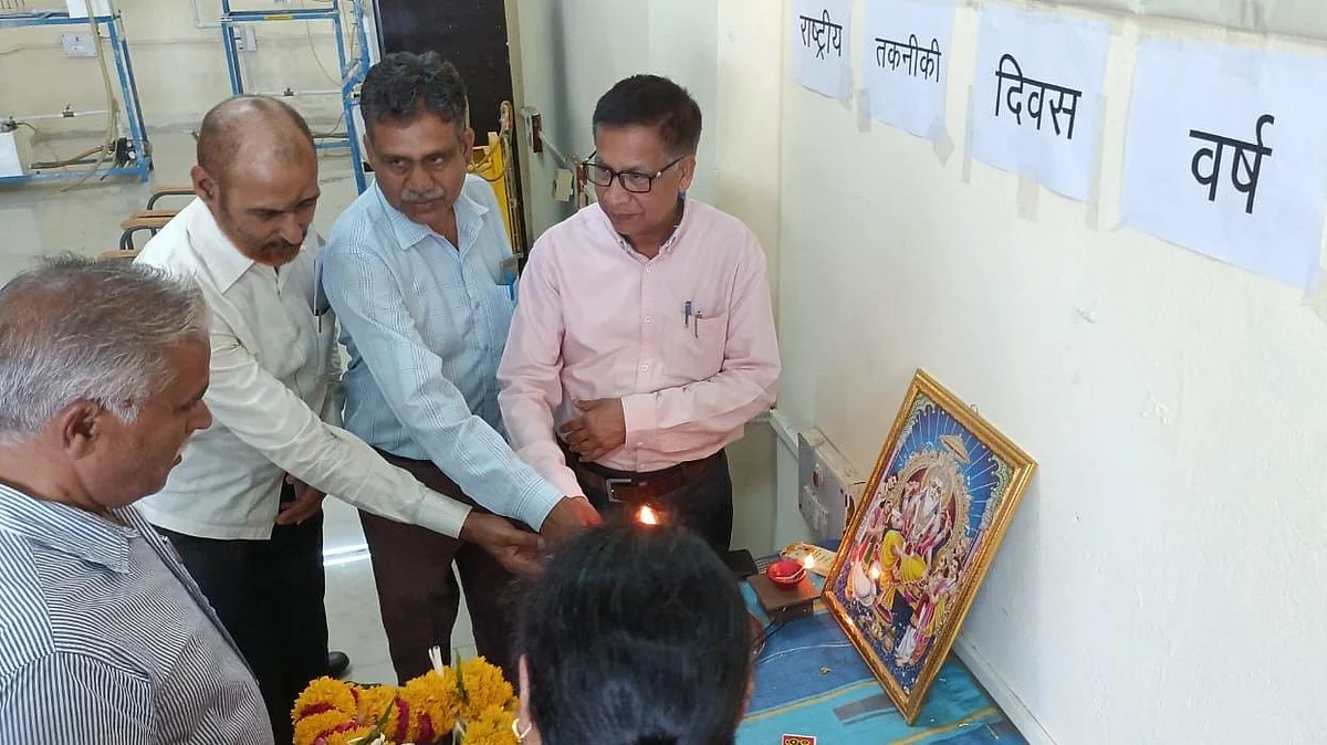 Guests light a lamp before the portrait of God Vishwakarma to mark National Technology Day in Ujjain on Thursday. | FP Photo