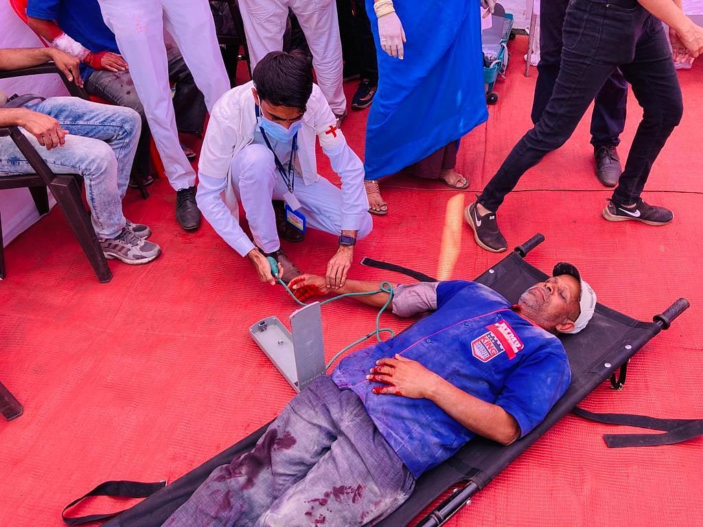 A paramedic checking BP of a person lying on stretcher