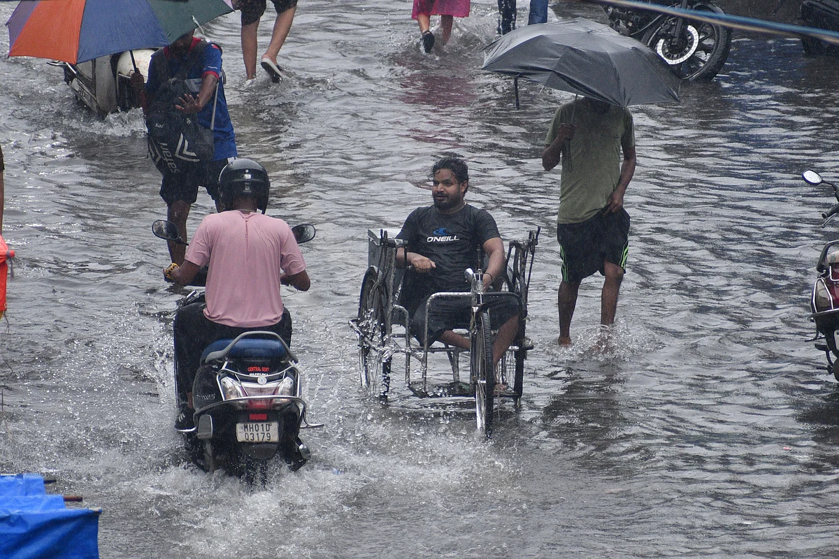 People wade through flooded road at Mumbai Central