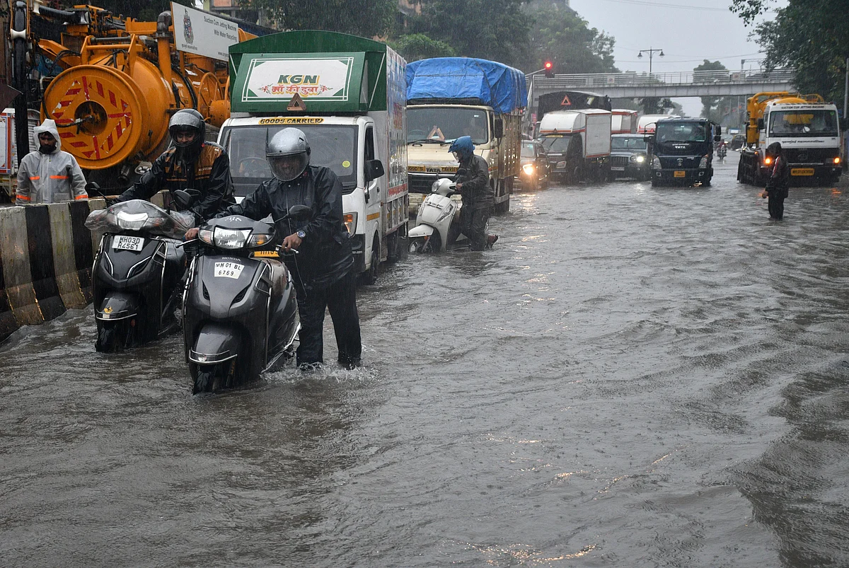 Motorists ride their vehicles through flooded road outside Dockyard Road station