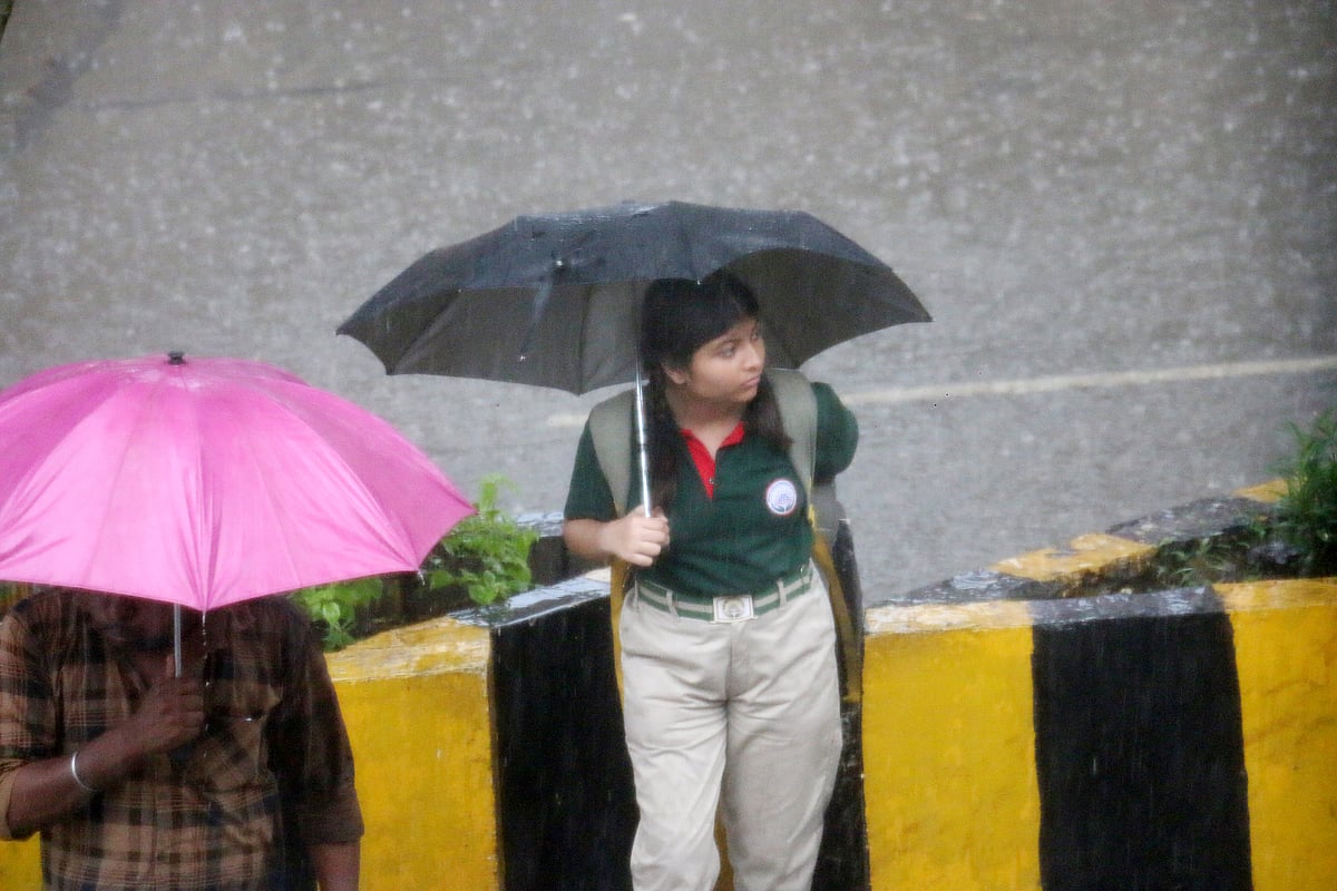 School girl waiting for her conveyance during rains