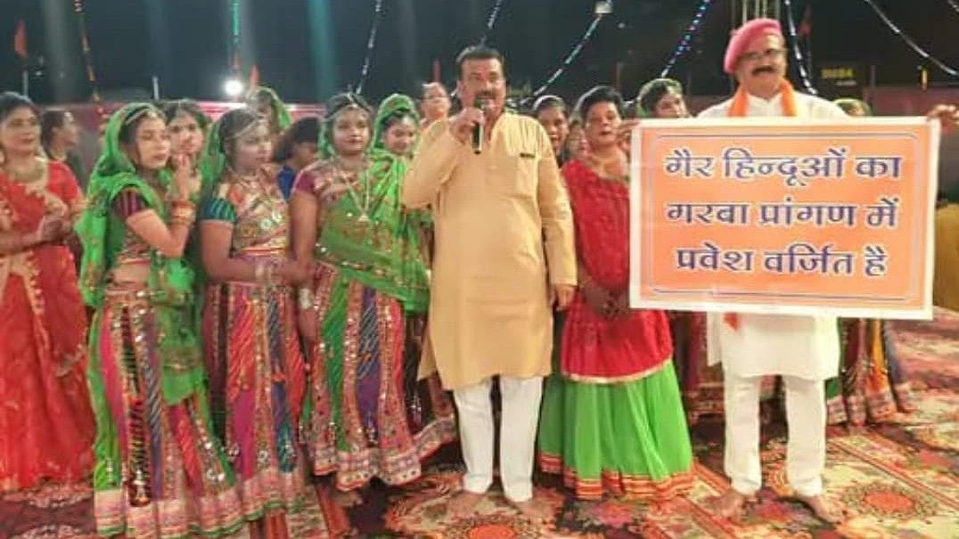 Garba organisers stand at pandal carrying notice board |