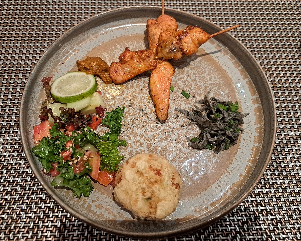 Starters plate with chicken skewers, fish patty and salad