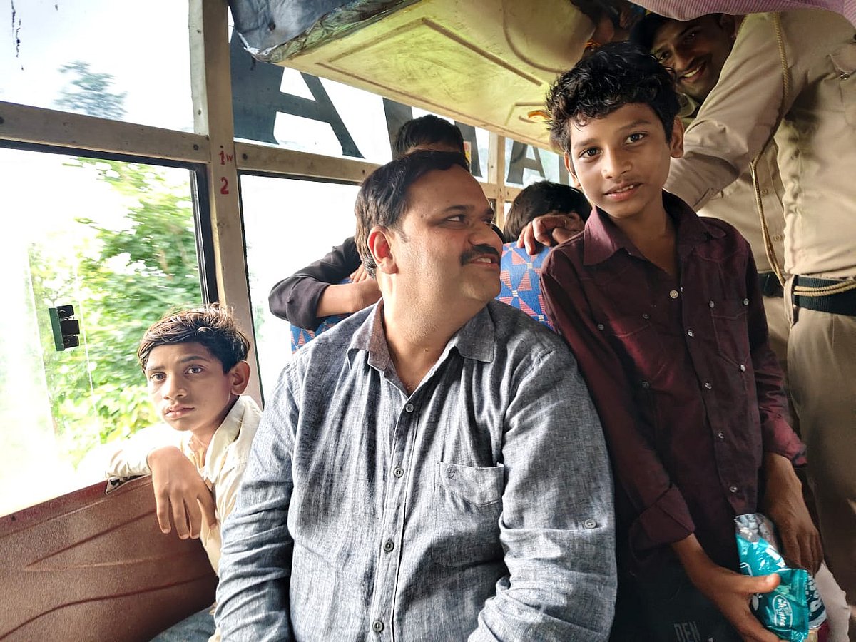 Collector Karmveer Sharma travelling with students on bus |