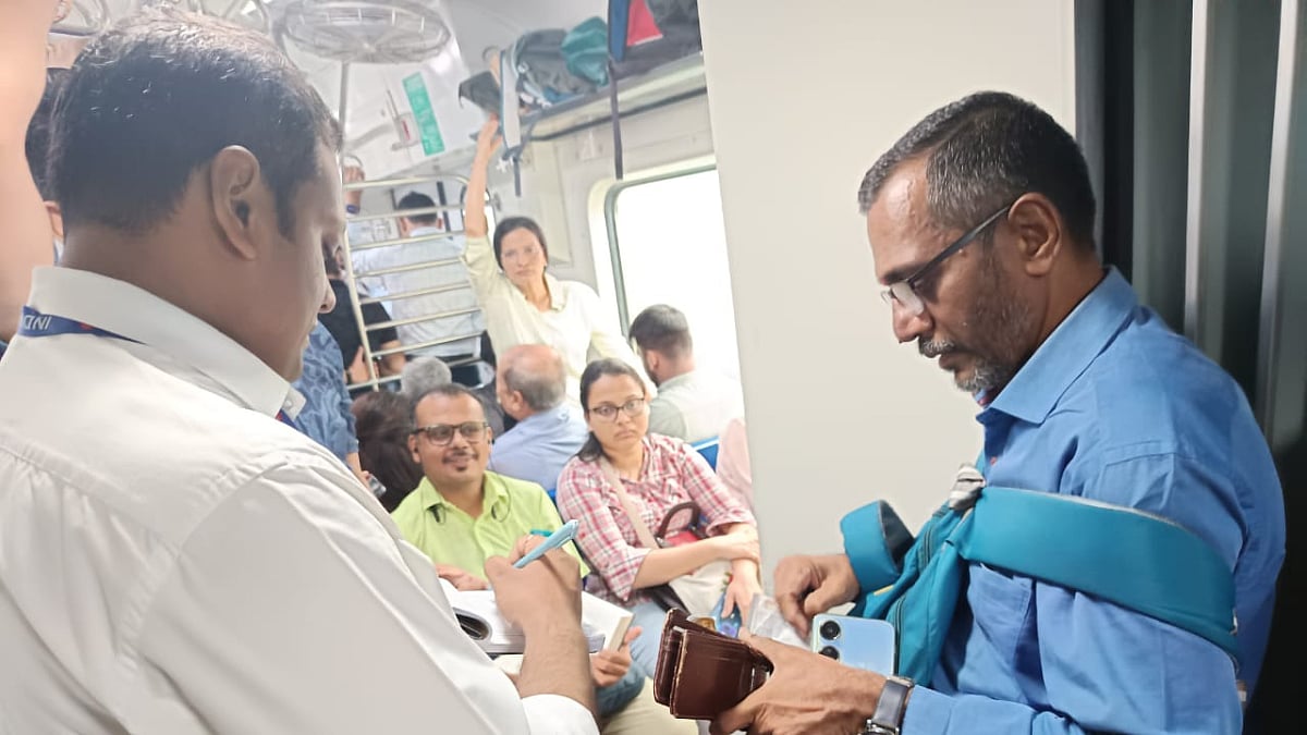 A ticket-checker (left) collecting fine from a ticketless passenger in an AC train. | X (@WesternRly)