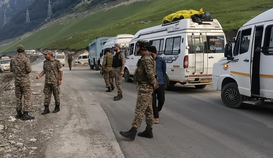 Security personnel stand vigilant along the route during the convoy