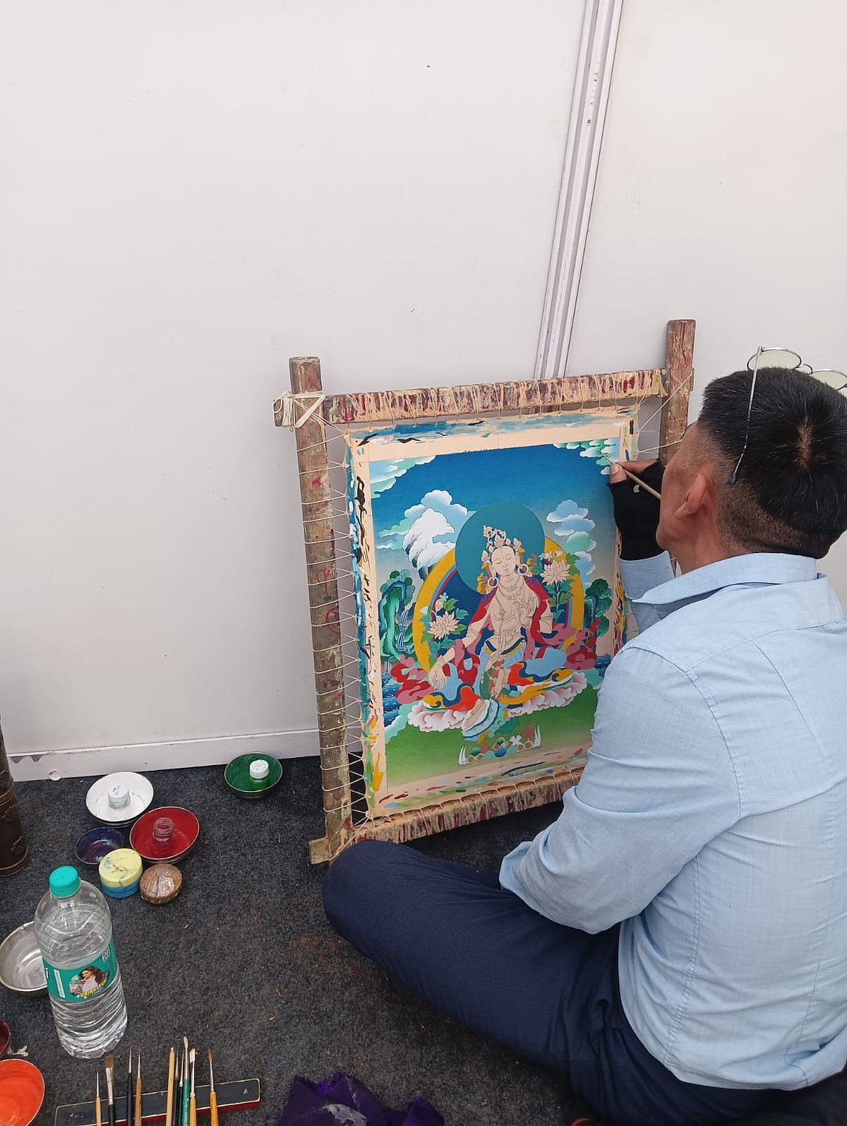 Tibetan artist creating Green Tara in Thangka style