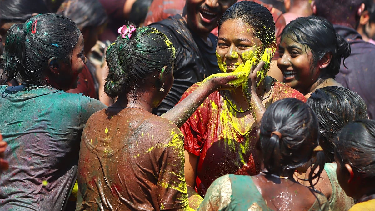 Friends apply bright colour on each other’s faces as they celebrate Holi together.