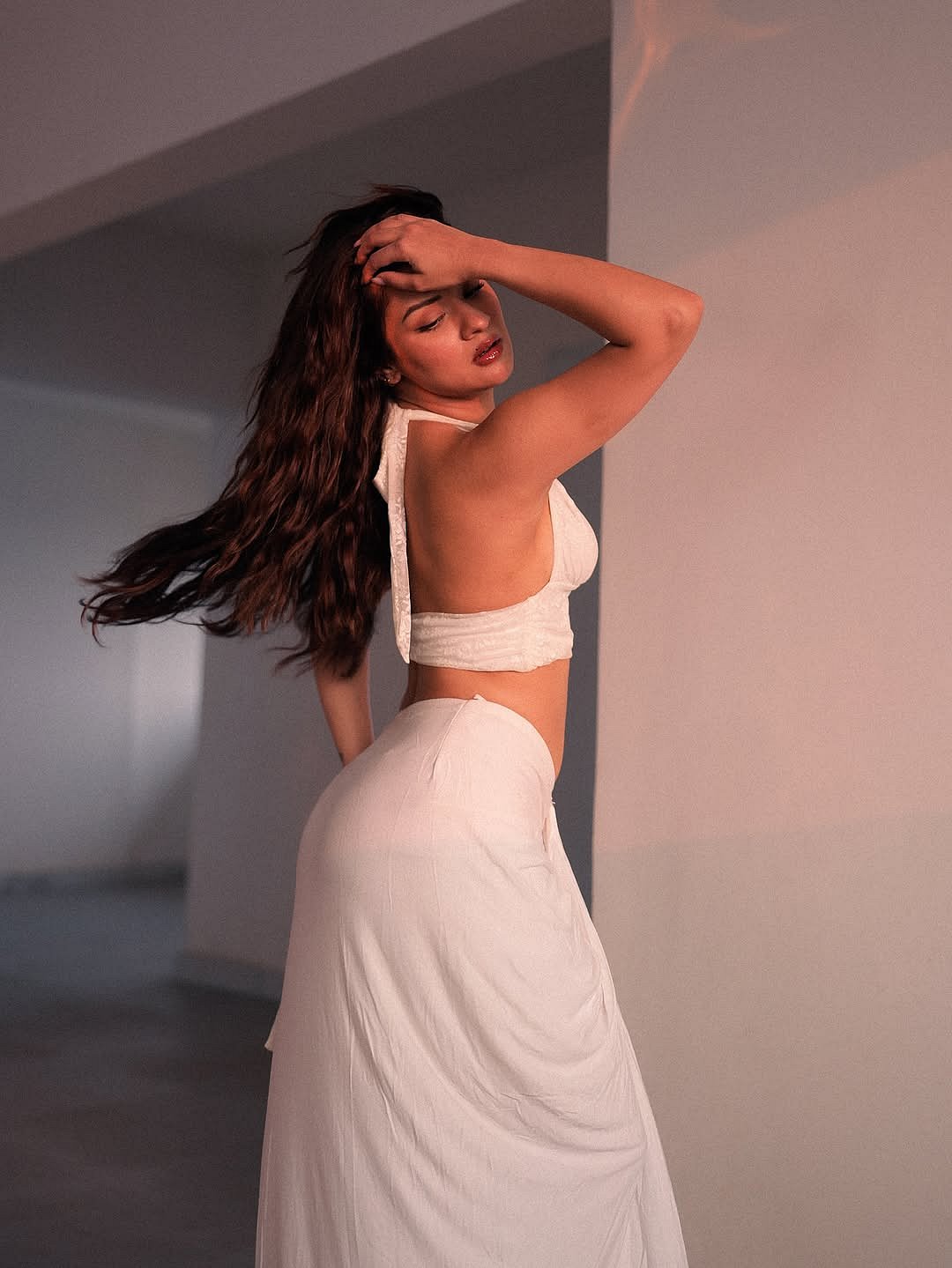 Her halter-neck style top features a deep neckline that adds a touch of bold femininity while keeping the look refined.