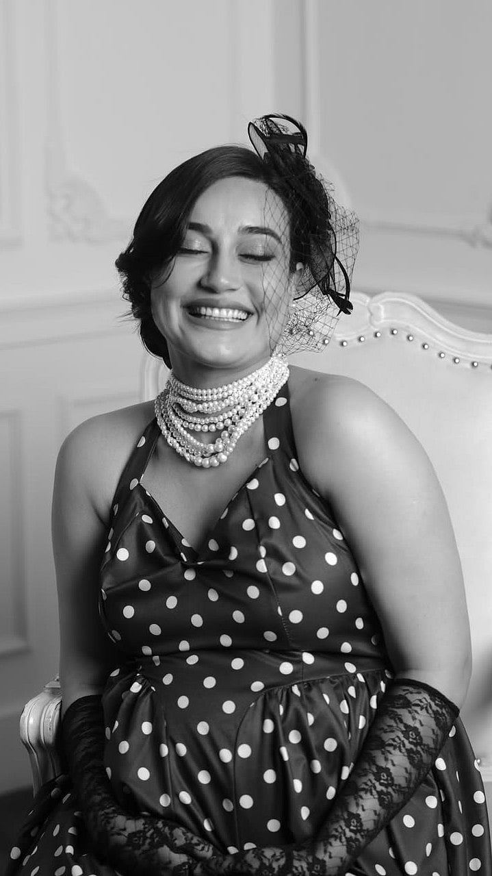 Her hair was styled in a neat, fuss-free bun, allowing the statement pearls and vintage-inspired details to remain the focus of the elegant maternity shoot.