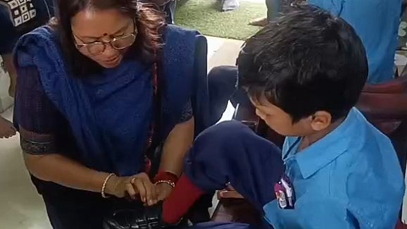 Collector Sits Beside Tribal Child, Helps Him Wear Socks And Tie Shoelaces In MP’s Dindori