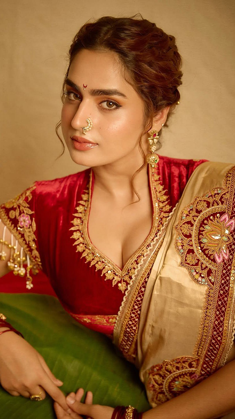 Ayesha accentuated the elegant look with traditional Maharashtrian nath, gold earrings, statement rings, and a stack of red bangles, paired with gold kadas


