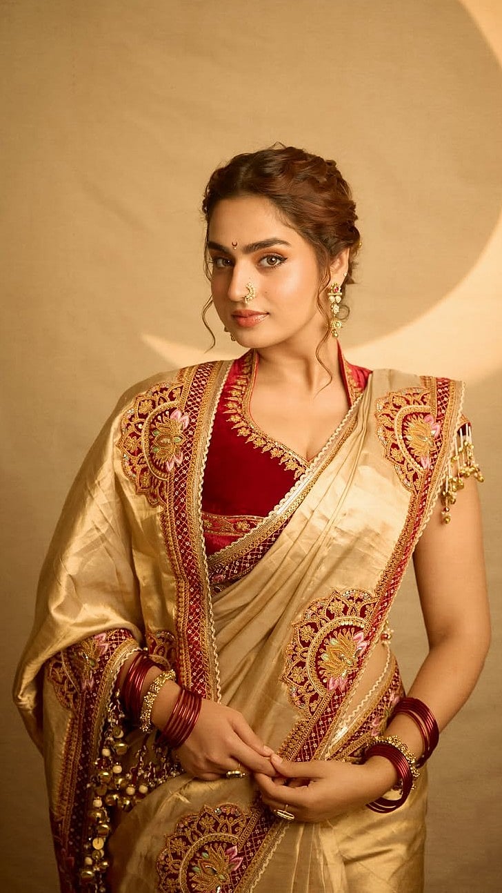 The saree featured elaborate borders covered in floral and paisley-inspired embroidery in red, gold, pink and green accents that stood out against the golden base