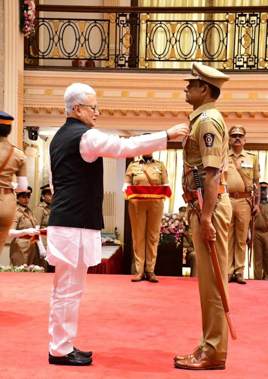 The Governor confers a medal on ACP Sanjay Mohite.