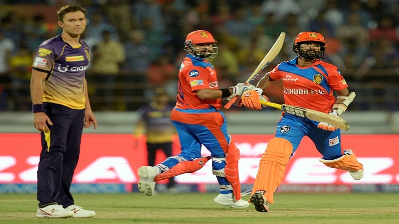 Gujarat Lions batsmans Dinesh Karthik (R) and Suresh Raina (C) run between the wickets during the 2017 Indian Premier League (IPL) Twenty20 cricket match between Gujarat Lions and Kolkata Knight Riders at the Saurashtra Cricket Association Stadium in Rajkot on April 7, 2017. —-IMAGE RESTRICTED TO EDITORIAL USE – STRICTLY NO COMMERCIAL USE—– GETTYOUT / AFP PHOTO / PUNIT PARANJPE / —-IMAGE RESTRICTED TO EDITORIAL USE – STRICTLY NO COMMERCIAL USE—– / GETTYOUT