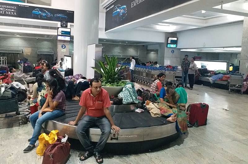 Tired passengers take shelter on conveyor belt at Mumbai airport