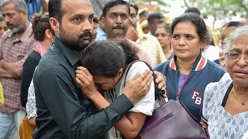 Indian journalist Gauri Lankesh’s sister Kavitha Lankesh (C) is consoled by a relative as her body to brought to the Ravindra Kalakshetra cultural centre in Bangalore on September 6, 2017./ AFP PHOTO / MANJUNATH KIRAN