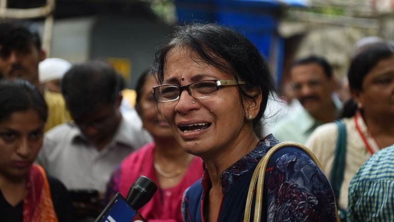 An Indian relative of a victim of a stampede on a railway bridge reacts outside a mortuary where bodies were being brought in Mumbai on September 29, 2017. / AFP PHOTO / PUNIT PARANJPE