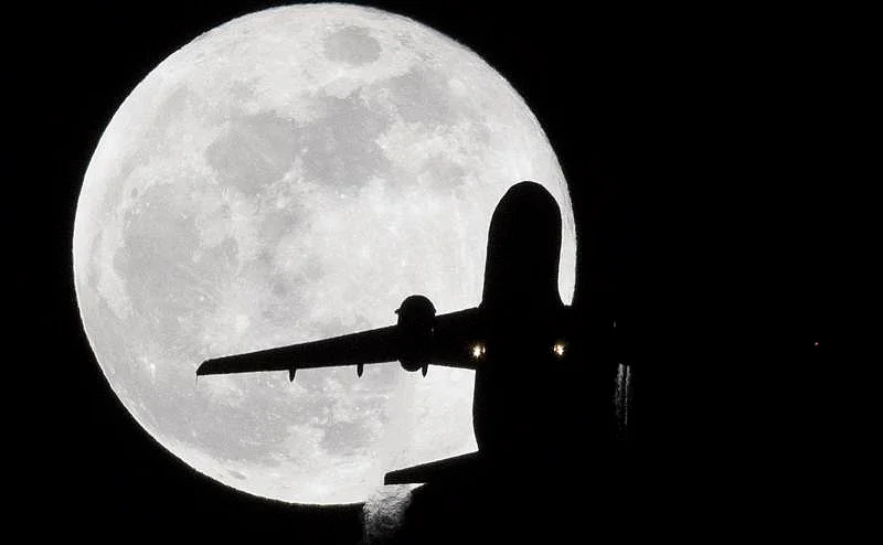 A British Airways Airbus A-319 aircraft from Stuttgart flies in front of a ‘super blue moon’ on its approach to London Heathrow Airport on January 31, 2018. / AFP PHOTO / Justin TALLIS
